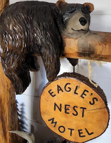 a wooden bear holding a sign that reads eagle next world at Eagle's Nest Motel in Priest River