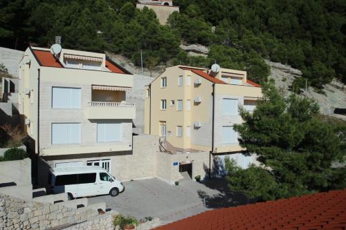 a white van parked in front of a building at Apartments Villa Astra & Pinija in Brela