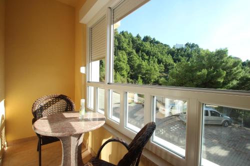 a room with a table and chairs and a large window at Apartments Villa Astra & Pinija in Brela