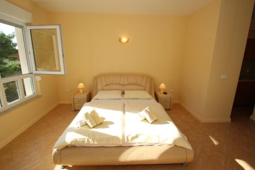 a bedroom with a bed with white sheets and pillows at Apartments Villa Astra & Pinija in Brela