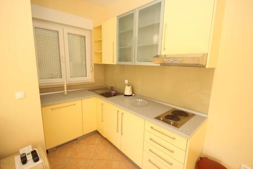 a small kitchen with white cabinets and a sink at Apartments Villa Astra & Pinija in Brela