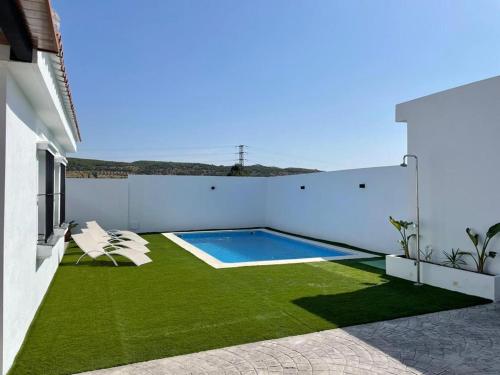 une cour avec une piscine et de l'herbe verte dans l'établissement Alojamiento Rural Buenavista, à Arcos de la Frontera