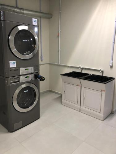 a laundry room with a washing machine and a counter at MaxLoft - Apto novo Smart Tv, lavanderia in Joinville