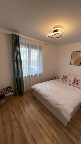 a bedroom with a white bed and a window at Nathallie Modern Apartments in Timişoara