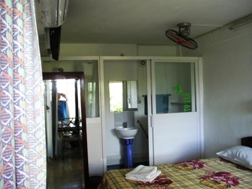 a bedroom with a bed and a sink at Auberge Le Saladier in Mahébourg