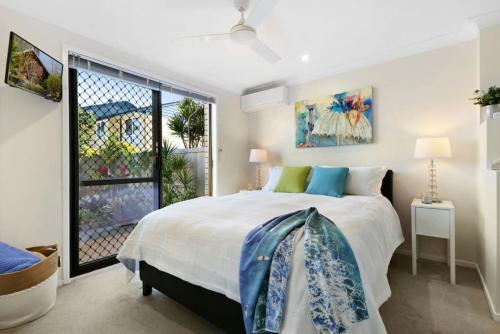 a bedroom with a large bed and a window at Tropical Suite PRIVATE CENTRAL BUDDINA STYLE by Custom Bnb Hosting in Buddina