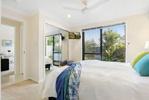 a bedroom with a large bed and a large window at Tropical Suite PRIVATE CENTRAL BUDDINA STYLE in Buddina
