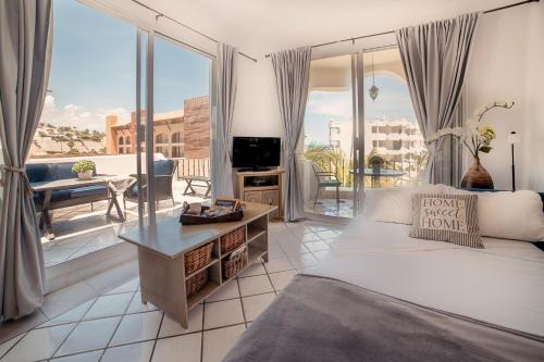 a bedroom with a bed and a view of a balcony at Beach Front Mykonos in San José del Cabo