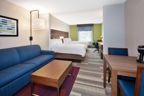 une chambre d'hôtel avec un lit et un canapé dans l'établissement Holiday Inn Express Hotel & Suites Warrenton, an IHG Hotel, à Warrenton