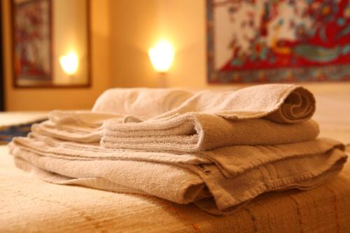 un mucchio di asciugamani seduti sopra un letto di Art Lincoln a Palermo