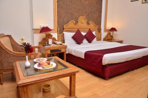 a hotel room with a bed and a tray of fruit on a table at Hotel K.C.Cross Road in Panchkula