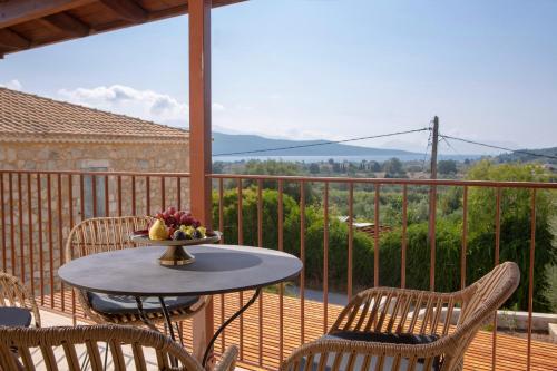 a table with a bowl of fruit on a balcony at Luxury Villa Happynest in Spasméni Vrísi