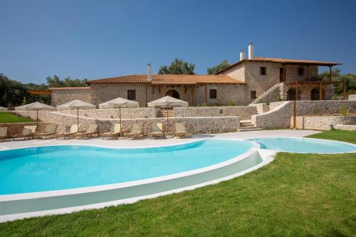 a large swimming pool in front of a house at Luxury Villa Happynest in Spasméni Vrísi