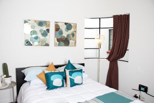 een slaapkamer met een bed met blauwe en oranje kussens bij LA CONDESA: BEAUTIFUL DESIGNED STUDIO in Mexico-Stad