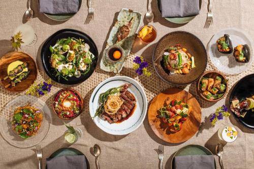 a table with many plates of food on it at Kimpton Alton Fisherman's Wharf by IHG in San Francisco