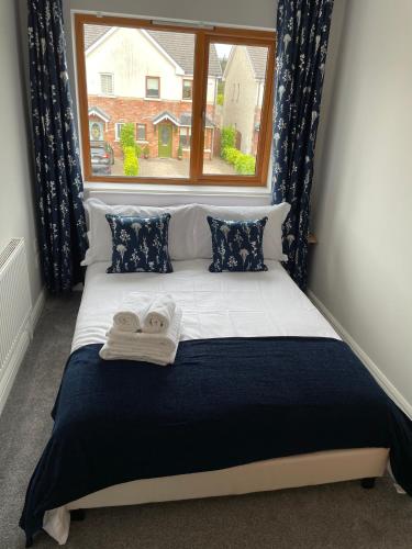 a bed with towels on it in front of a window at Private Double Room & Bathroom in Naas