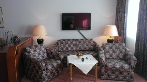 a living room with two chairs and a table at Hotel-Restaurant Schwanen in Weil am Rhein
