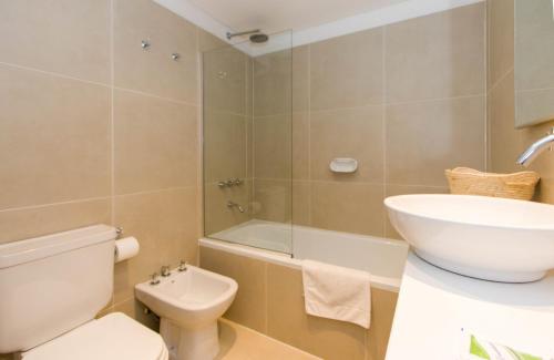 a bathroom with a toilet and a sink and a shower at Austral Departamentos in Ushuaia