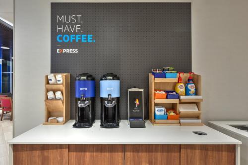 a counter with some bottles of coffee on it at Holiday Inn Express & Suites Jersey City - Holland Tunnel by IHG in Jersey City