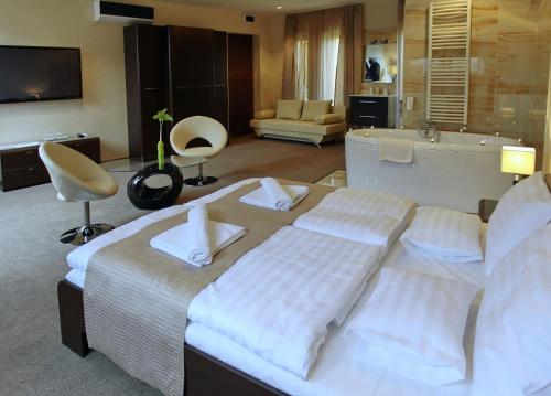 a hotel room with a bed and a bath tub at Hotel Brill Orosháza in Orosháza