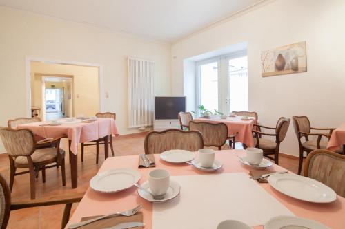 a dining room with tables and chairs and a tv at Hotel Herzog in Düsseldorf