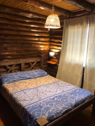 a bedroom with a bed and a chandelier at Mirador de Montaña in Ciudad Lujan de Cuyo