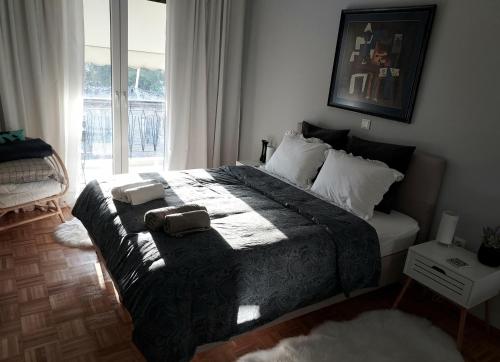ein Schlafzimmer mit einem großen Bett und einem Fenster in der Unterkunft Fully equiped Design Apartment with excellent view/ easy parking in Athen