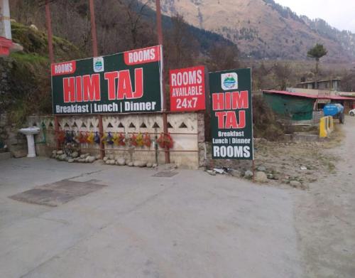 a bunch of signs that are on the side of a road at Him Taj by StayApart in Manāli