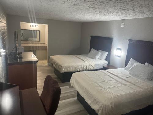 a hotel room with two beds and a sink at Stratford House Inn in Branson