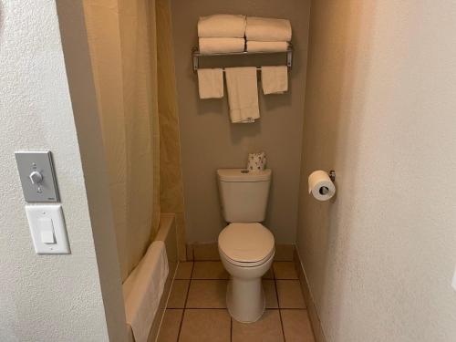 a small bathroom with a toilet and towels at Stratford House Inn in Branson