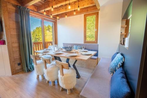 une salle à manger avec une table, des chaises et un canapé dans l'établissement Hauts de Chantemouche 17, à Méribel