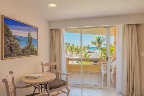 a room with a table and chairs and a view of the ocean at Posada Real Los Cabos in San José del Cabo