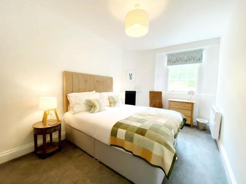Habitación blanca con cama y ventana en Tramontane Apartment at Hesketh Crescent, en Torquay