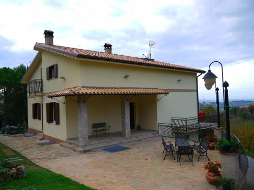 une maison avec une terrasse, une table et des chaises dans l'établissement B&B La Collina Dorata, à Offagna