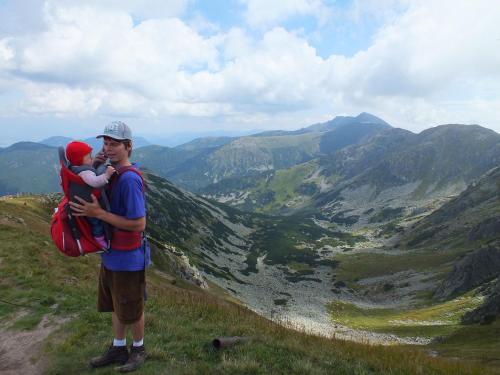 a man holding a child on top of a mountain at Chaty Jasná in Demanovska Dolina