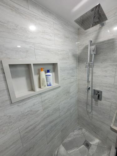 a bathroom with a shower with white tiles at Guest House Basement - Master Bedrooms in Bayview Village in Toronto
