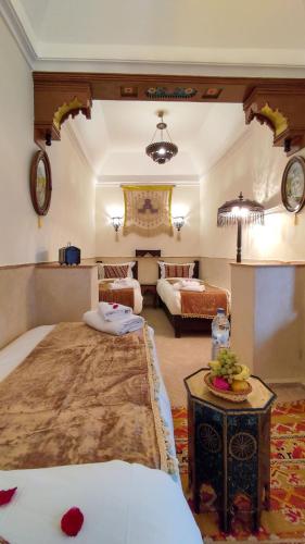 マラケシュにあるRIAD DAR En-Nawatのベッド2台とテーブルがあるホテルの部屋
