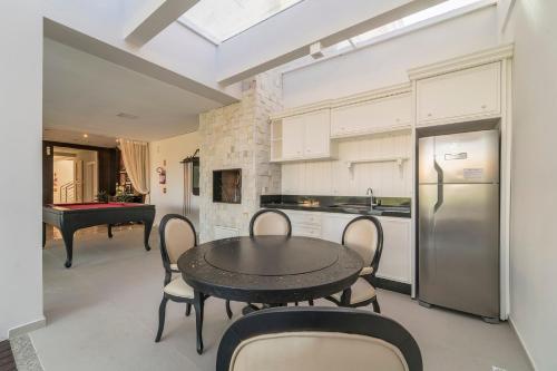 a kitchen with a table and chairs and a pool table at Costa Brava in Bombinhas