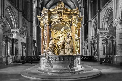 a large gold statue in a large cathedral at Reims Saint-Remi in Reims