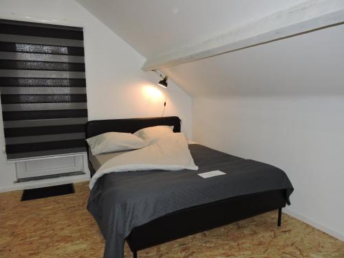 a bed in a room with a black and white wall at Villa de fays in Theux