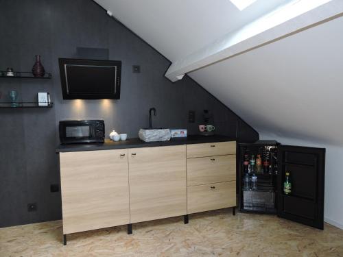 a kitchen with a refrigerator and a tv on the wall at Villa de fays in Theux