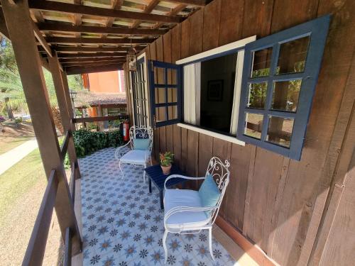 a porch with two chairs and a window at Saison Resort & Spa in Itaipava