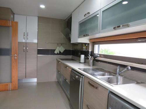 a kitchen with a sink and a counter top at Sunset Street Beach house in Lourinhã