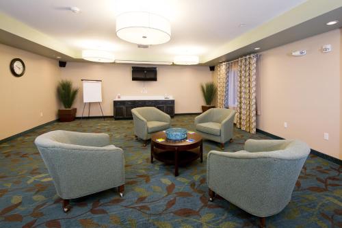 a meeting room with chairs and a table and a screen at Candlewood Suites Greeley by IHG in Greeley