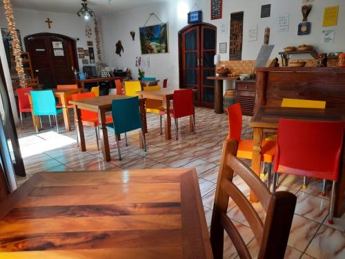a dining room with tables and colorful chairs at Pousada Estrela Mare in São Sebastião
