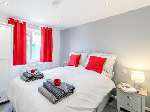 a bedroom with a large white bed with red pillows at Hill Crest Lodge 2 in Hemswell