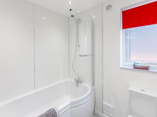 a white bathroom with a tub and a window at Hill Crest Lodge 2 in Hemswell