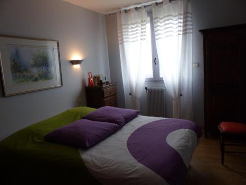 Un dormitorio con una cama con almohadas moradas. en Résidence Saint-Nicolas Granville, en Granville