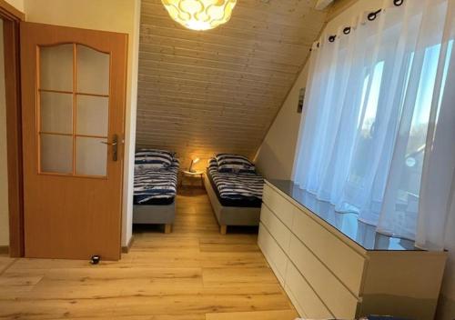 a small room with two beds and a window at Domek Maciej in Kopalino