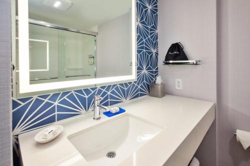 a bathroom with a white sink and a mirror at Holiday Inn Express Hotel & Suites Virginia Beach Oceanfront, an IHG Hotel in Virginia Beach